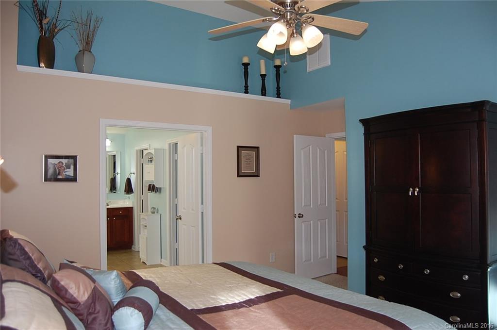 5831 Ringneck Road Charlotte, NC 28216 - Photo 11 of 20 a bedroom with a bed and a chandelier