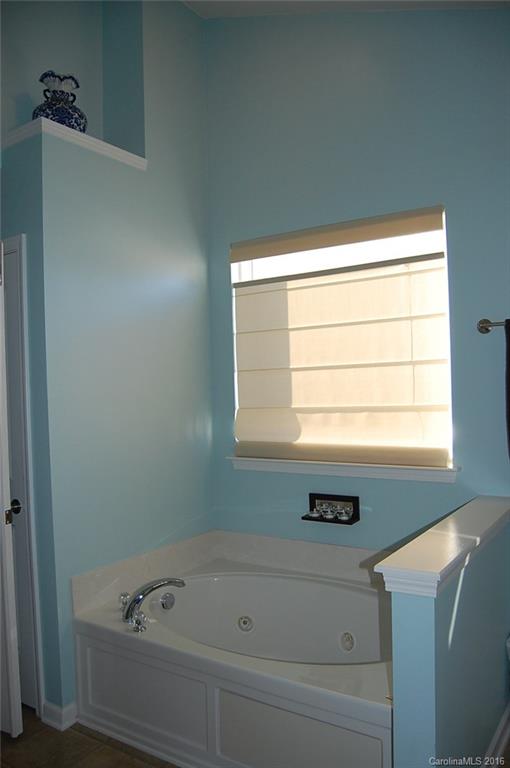 5831 Ringneck Road Charlotte, NC 28216 - Photo 12 of 20 a bathroom with a bathtub and next to a window