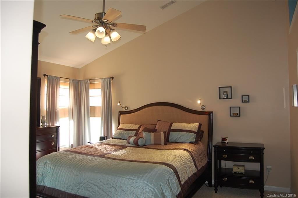 5831 Ringneck Road Charlotte, NC 28216 - Photo 9 of 20 a bedroom with a bed and a chandelier