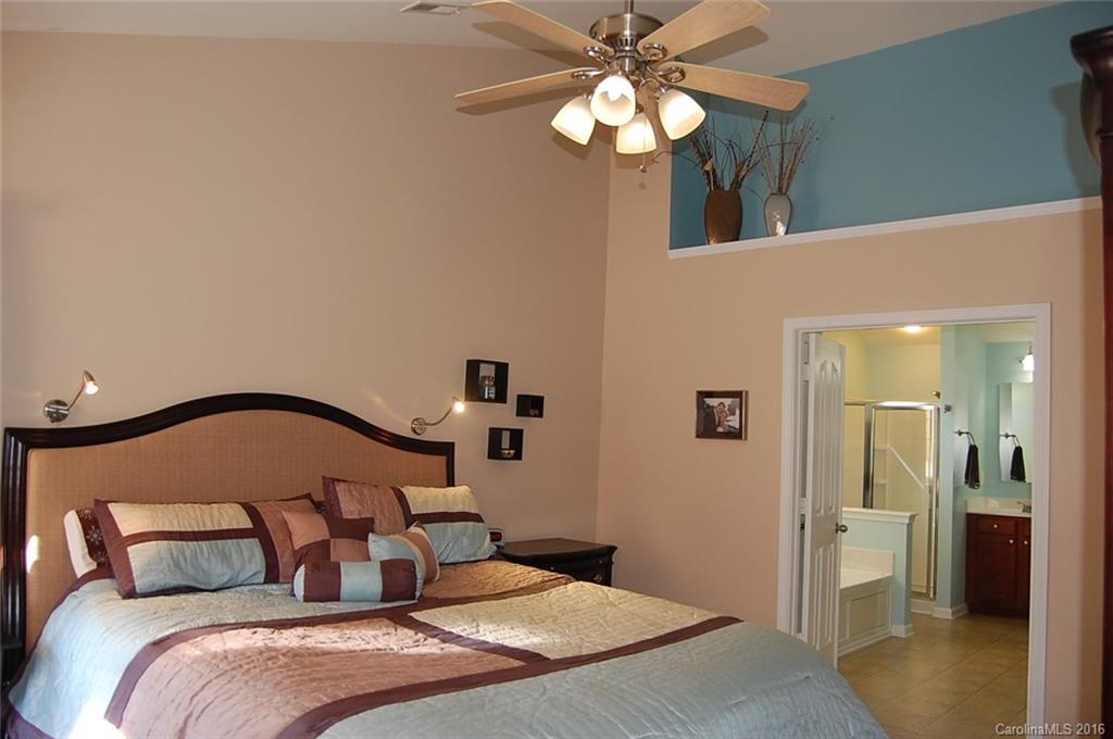 5831 Ringneck Road Charlotte, NC 28216 - Photo 10 of 20 a bedroom with a large bed and a chandelier