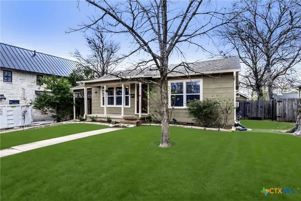 a backyard of a house with table and chairs