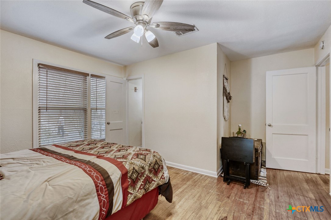 3307 Larry Lane Austin, TX 78722 - Photo 19 of 27 a bedroom with a bed and a chandelier