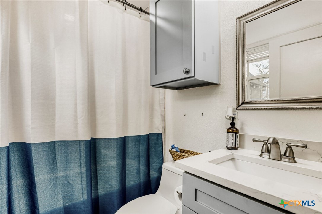 3307 Larry Lane Austin, TX 78722 - Photo 23 of 27 a bathroom with a sink vanity mirror and toilet