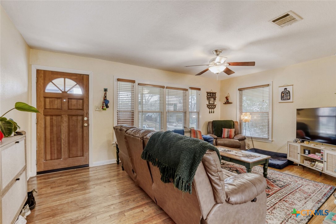 3307 Larry Lane Austin, TX 78722 - Photo 3 of 27 a living room with furniture a flat screen tv and a floor to ceiling window