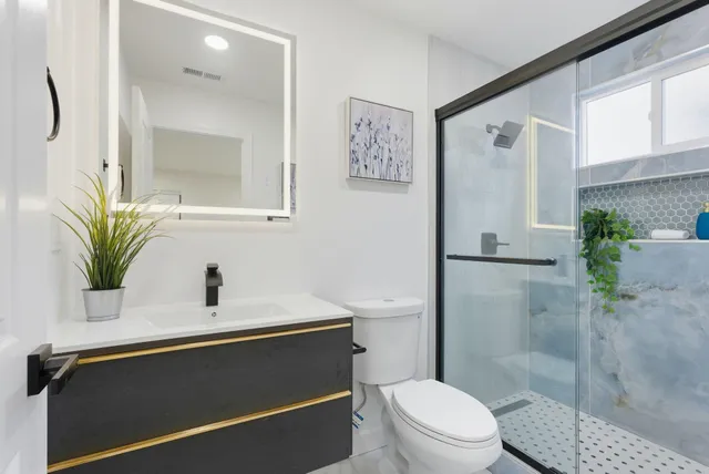 a bathroom with a sink a toilet and shower