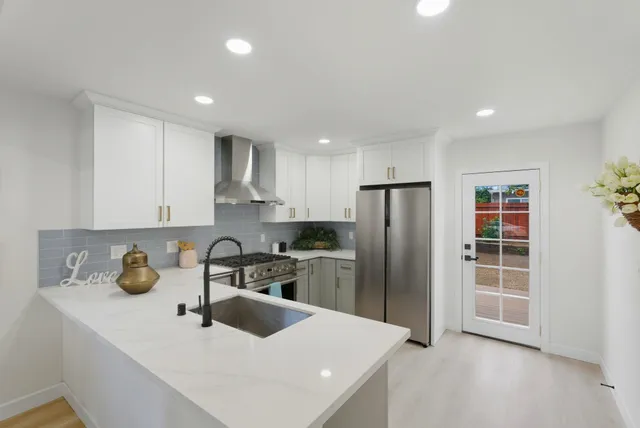 a kitchen with a sink a refrigerator and cabinets