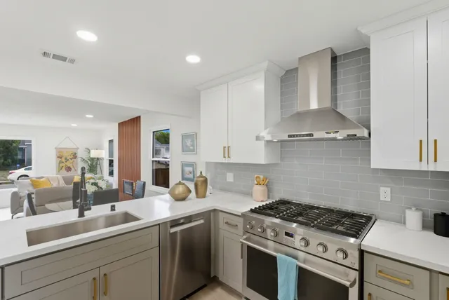 a kitchen with stainless steel appliances a sink a stove and cabinets