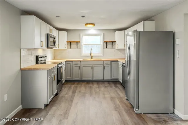 a kitchen with a sink a stove refrigerator and cabinets