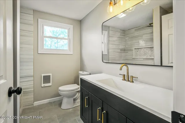 a bathroom with a sink a toilet a mirror and a window