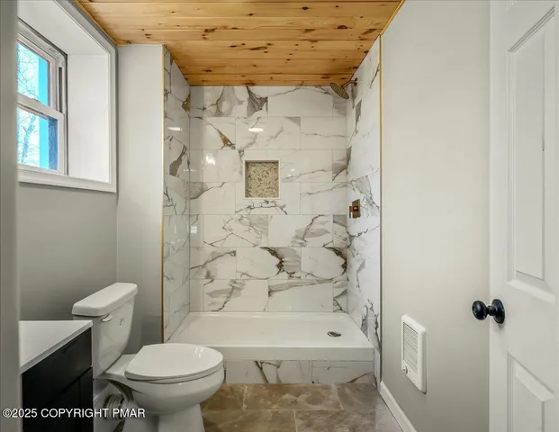 a bathroom with a toilet and a shower