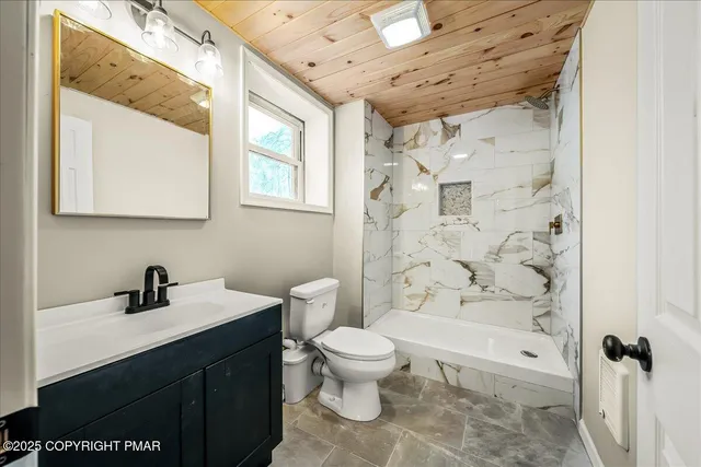 a bathroom with a sink a toilet and shower