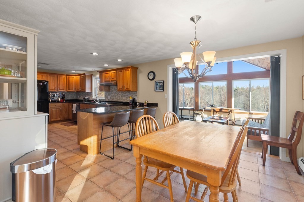 27 Brush Hill Road Merrimac, MA 01860 - Photo 4 of 26 a dining area with furniture a chandelier and kitchen view