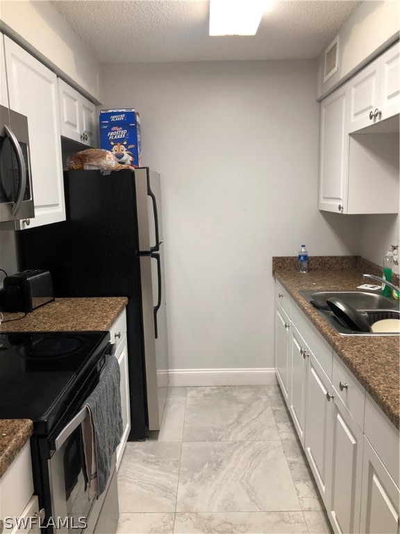 5325 Summerlin Road, Unit 2514 Fort Myers, FL 33919 - Photo 3 of 9 a kitchen with granite countertop a stove top oven microwave and sink