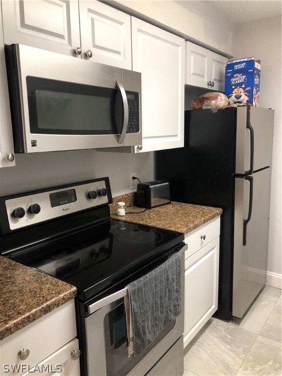 5325 Summerlin Road, Unit 2514 Fort Myers, FL 33919 - Photo 4 of 9 a kitchen with stainless steel appliances a stove microwave and refrigerator