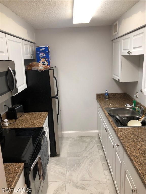 5325 Summerlin Road, Unit 2514 Fort Myers, FL 33919 - Photo 6 of 9 a kitchen with granite countertop a stove and a refrigerator