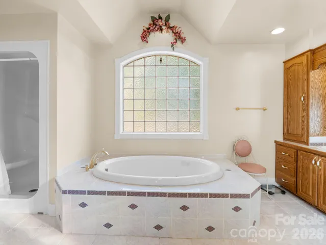 a bathroom with a tub sink and mirror
