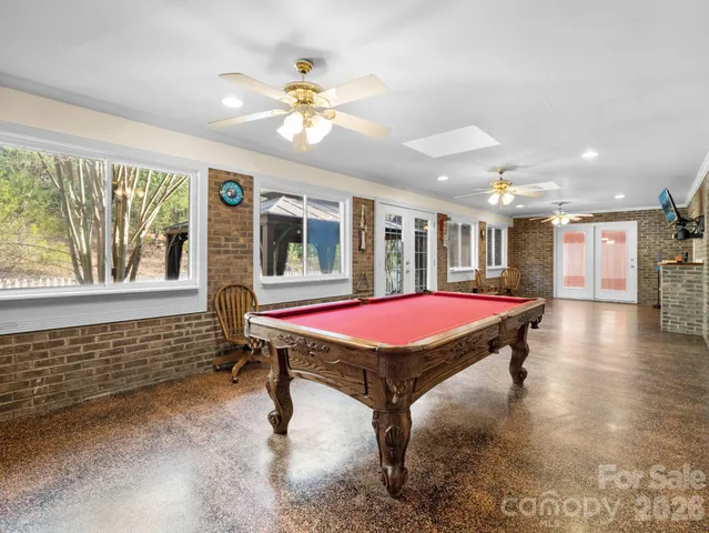 a room with pool table and windows