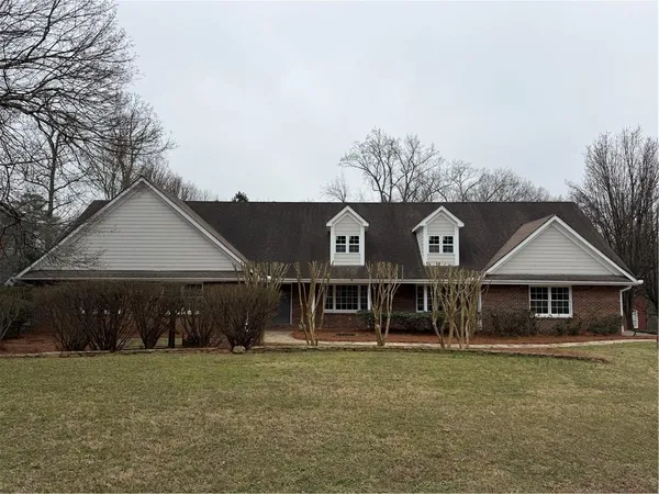 a front view of a house with a garden and parking space