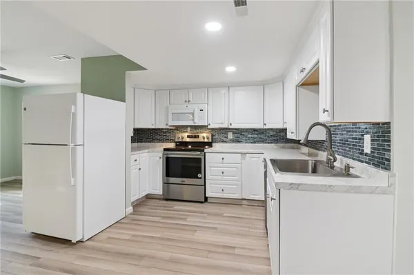 a bathroom with a granite countertop sink a toilet and shower