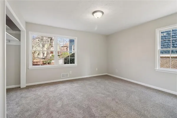 a view of an empty room with window and fan