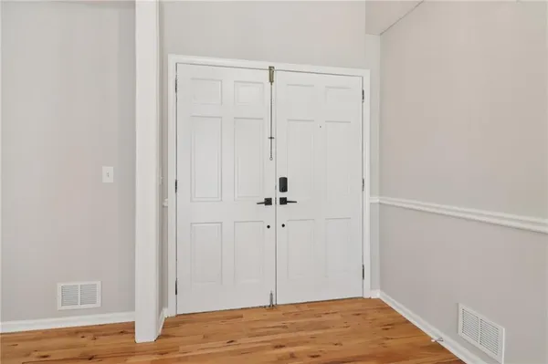 a view of empty room with wooden floor and fireplace