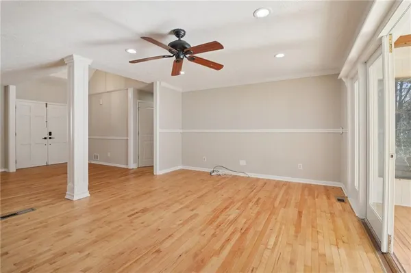 a view of empty room with wooden floor and windows
