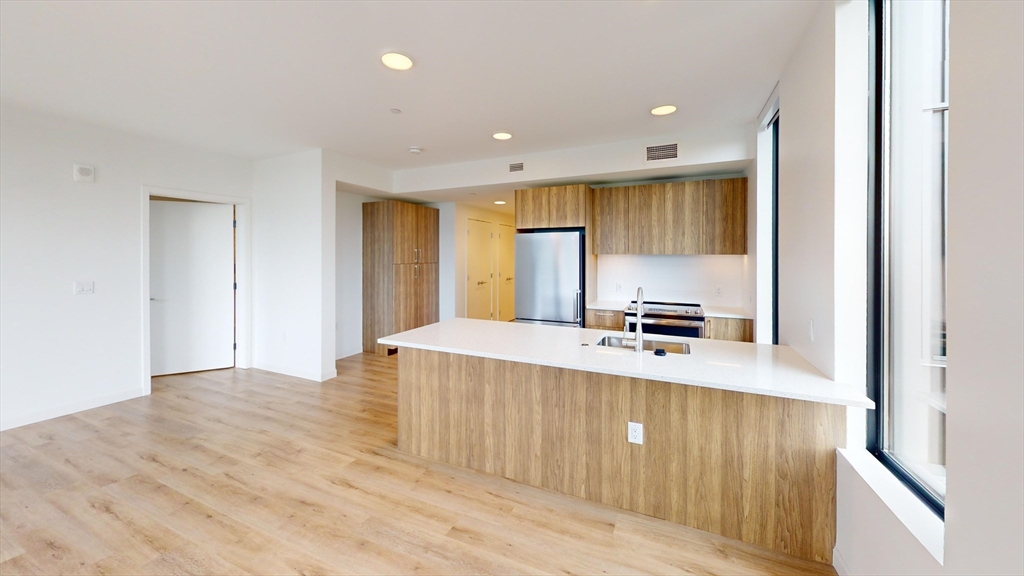 60 Kilmarnock Street, Unit 842 Boston, MA 02215 - Photo 1 of 13 a large kitchen with stainless steel appliances a large counter top a sink and a refrigerator