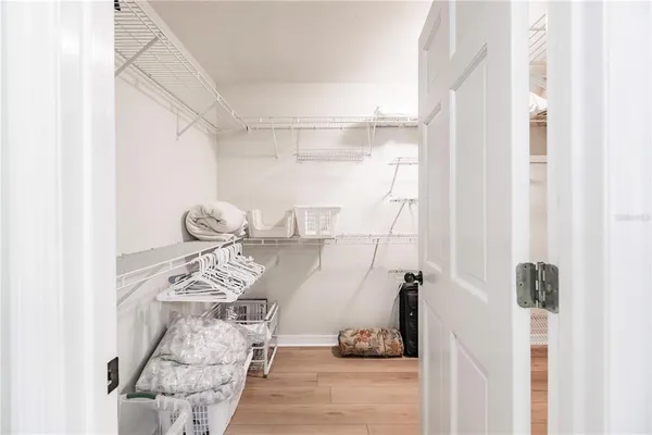 a large white kitchen with a window and refrigerator