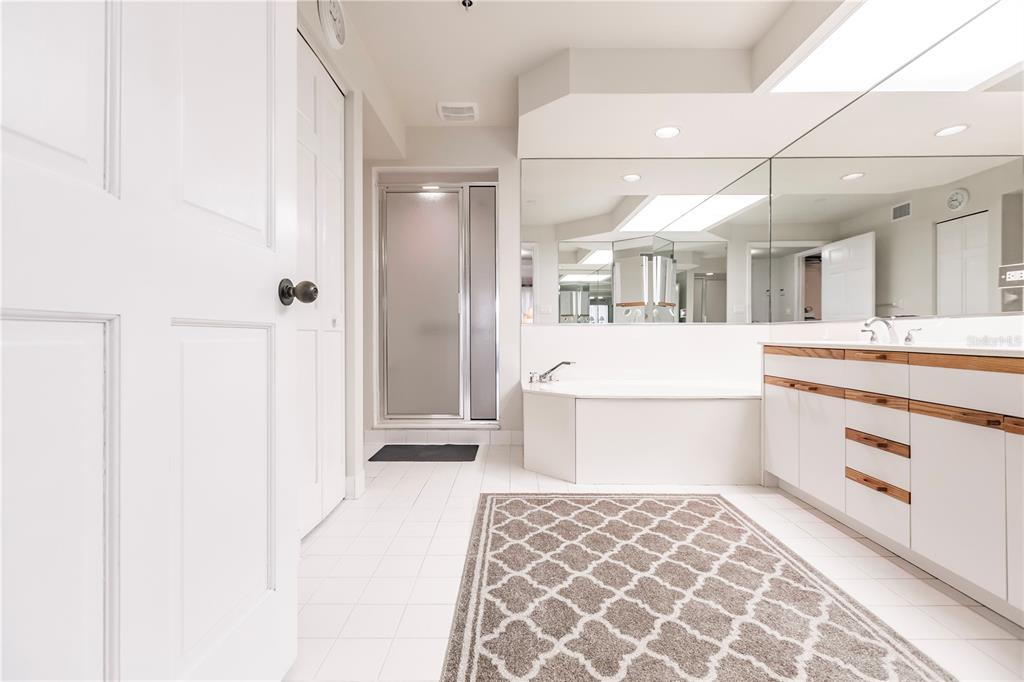 11000 Placida Road, Unit 2201 Placida, FL 33946 - Photo 31 of 43 a large white bathroom with a sink a mirror and a shower