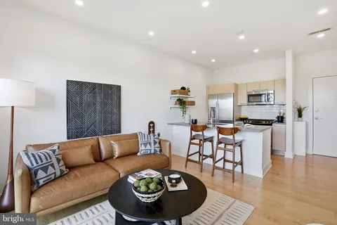 a living room with furniture a rug and kitchen view