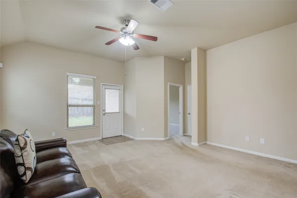 an empty room with windows and ceiling fan