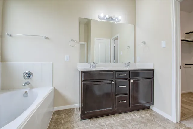 a bathroom with a tub sink and mirror