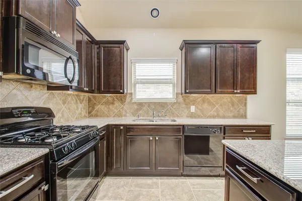 a kitchen with stainless steel appliances granite countertop a stove and a sink