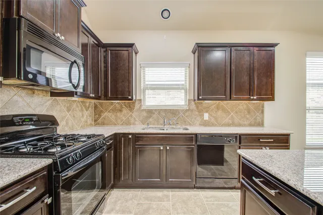 a kitchen with stainless steel appliances granite countertop a stove and a sink