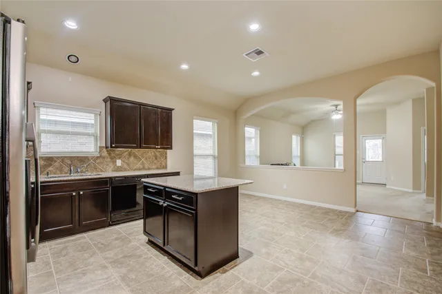 a large kitchen with stainless steel appliances granite countertop a sink and cabinets