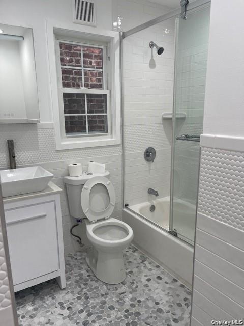 235 East 235th Street Bronx, NY 10470 - Photo 11 of 13 a bathroom with a granite countertop toilet a sink and a bathtub