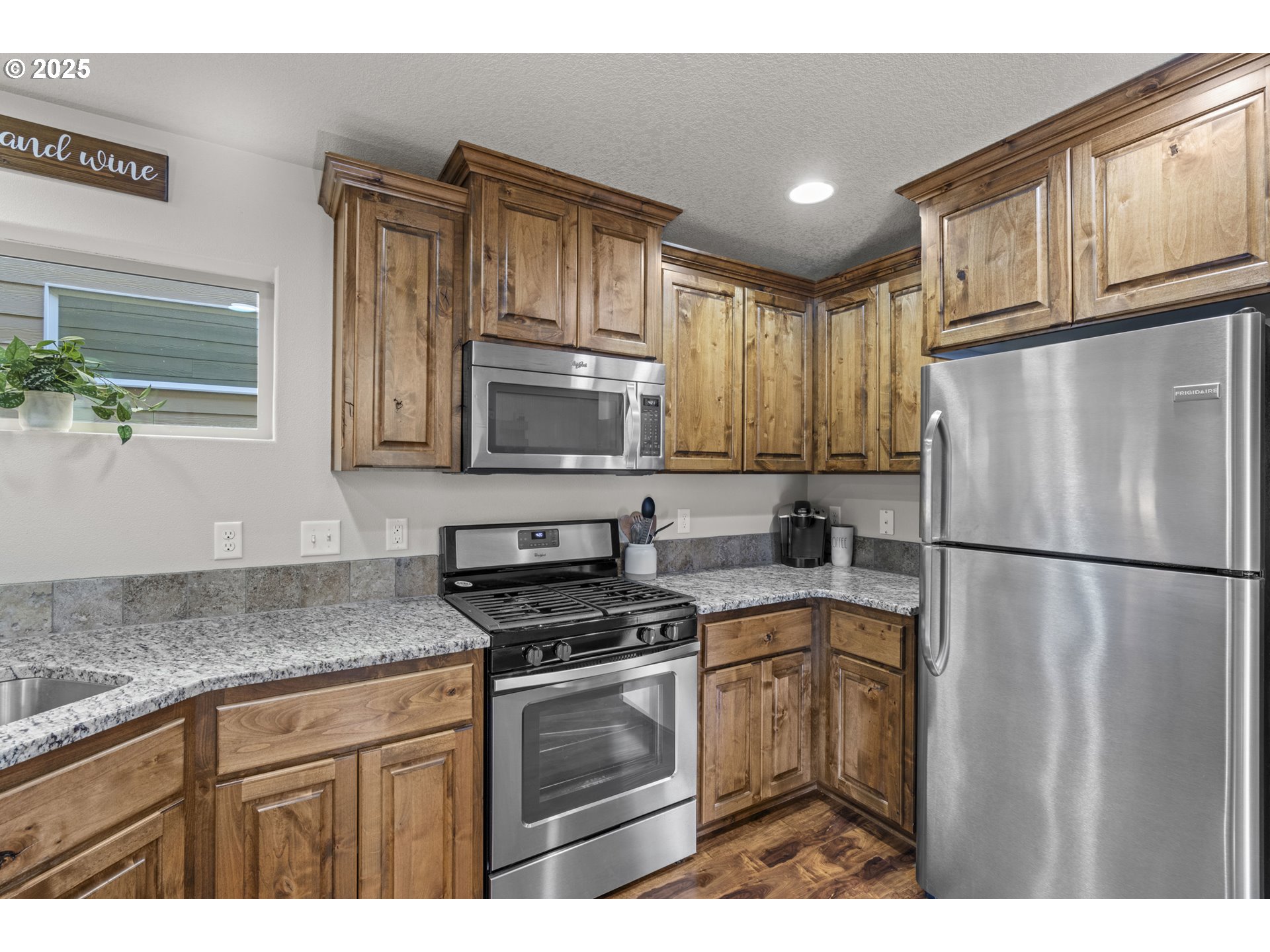 113 Northwest 76th Street Vancouver, WA 98665 - Photo 12 of 33 a kitchen with granite countertop a refrigerator sink stove and microwave