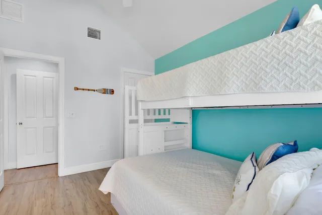 a bedroom with a bed wooden floor and window
