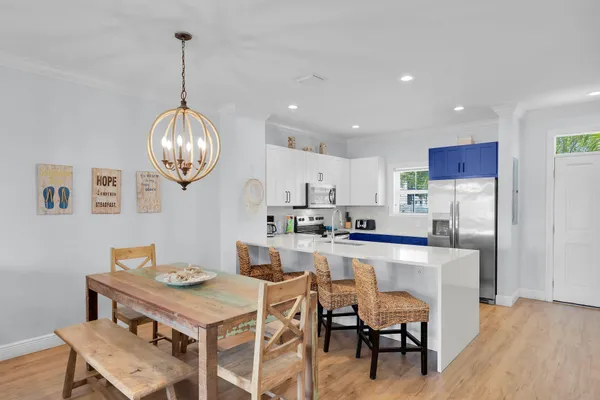 a kitchen with a dining table chairs and white cabinets