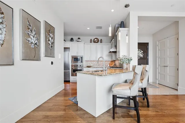 a kitchen with white cabinets and stainless steel appliances