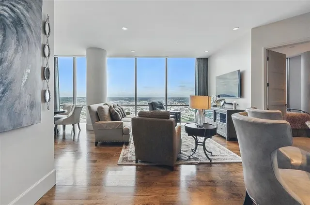 a living room with furniture a refrigerator and kitchen view