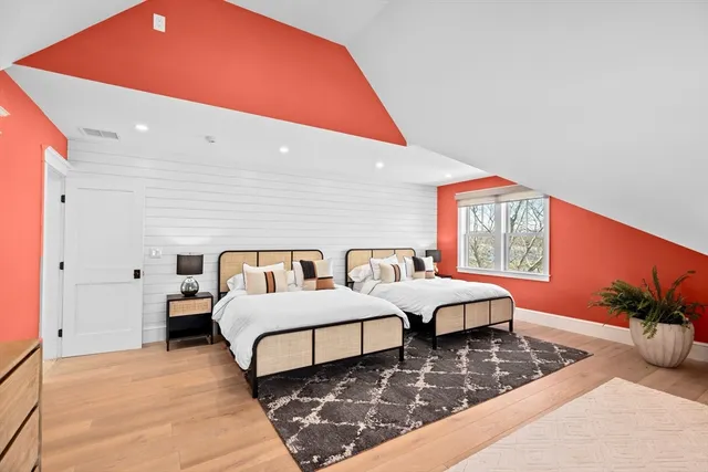 a spacious bedroom with two beds and potted plant