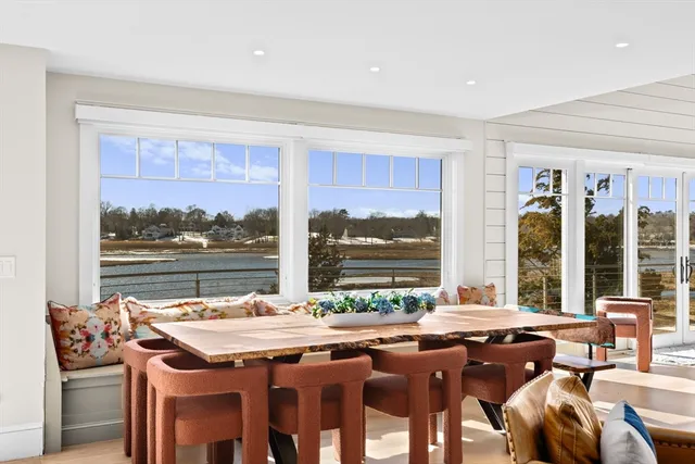 a dining hall with stainless steel appliances granite countertop a stove and a dining table chair