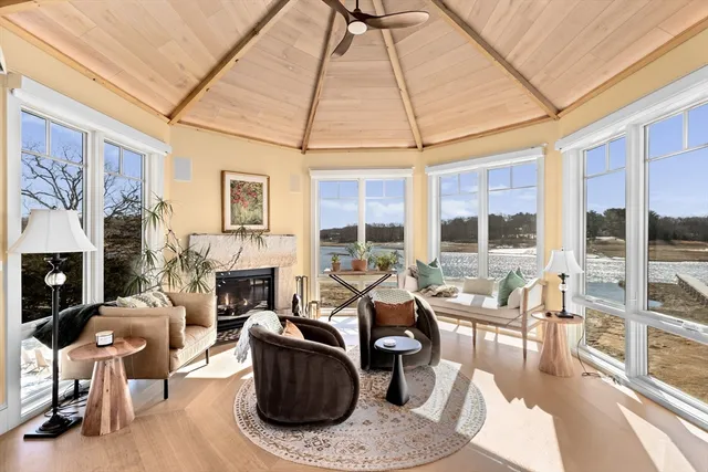 a living room with furniture a fireplace and a floor to ceiling window