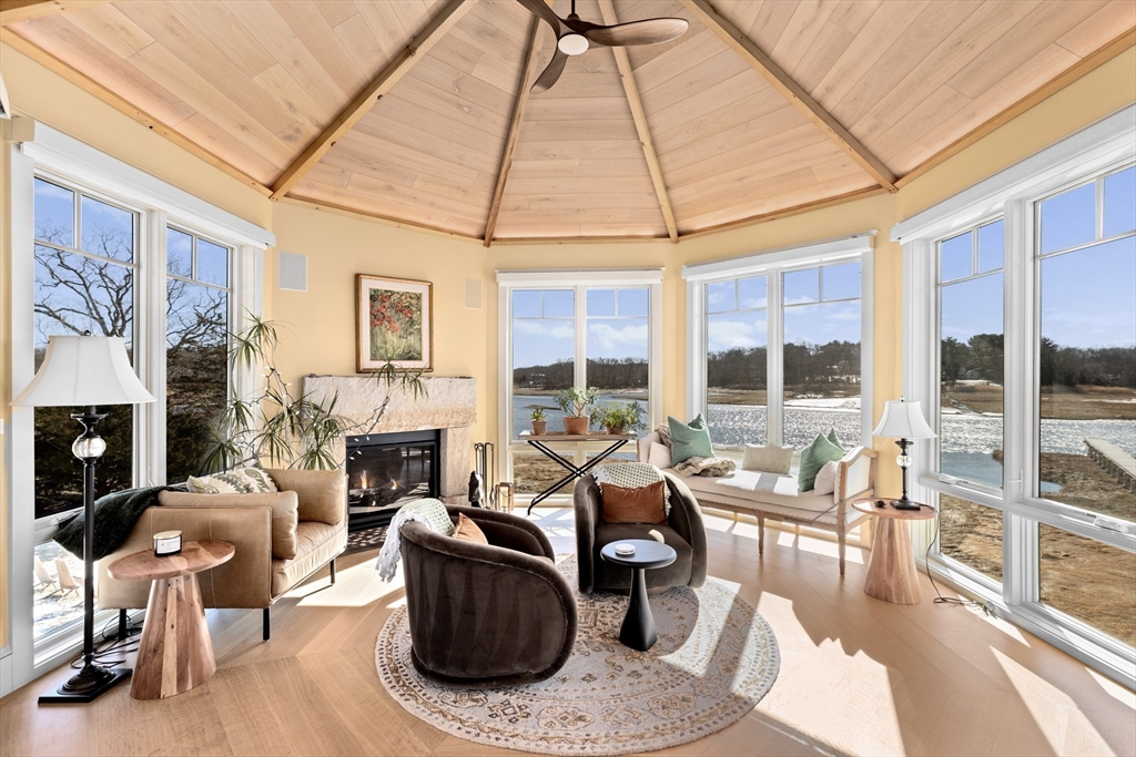 67 Border Street Scituate, MA 02066 - Photo 10 of 42 a living room with furniture a fireplace and a floor to ceiling window