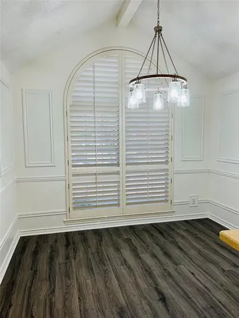 a view of a room with wooden floor and white walls