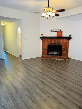 a view of a livingroom with a fireplace a chandelier and wooden floor