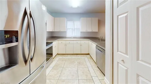 a kitchen with white cabinets a sink and stainless steel appliances