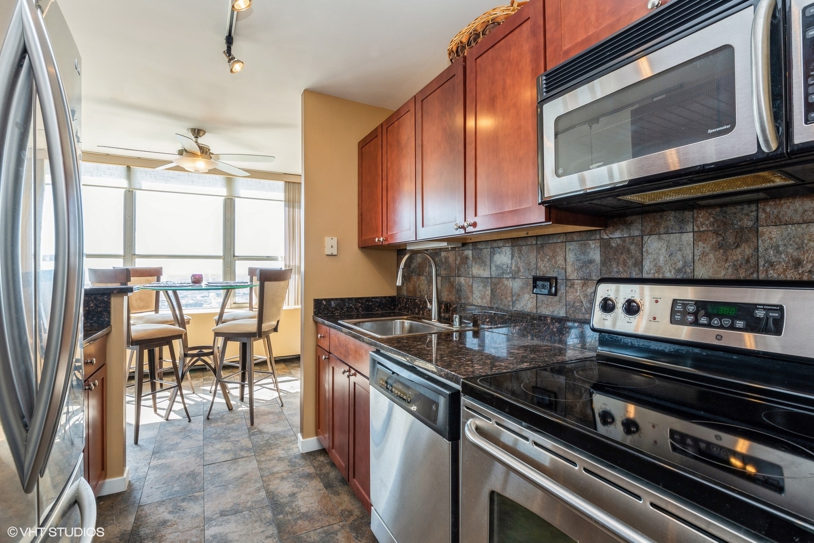 655 West Irving Park Road, Unit 4617 Chicago, IL 60613 - Photo 8 of 33 a kitchen with a stove a sink and a microwave