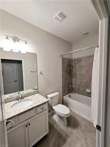a bathroom with a granite countertop sink a toilet and shower